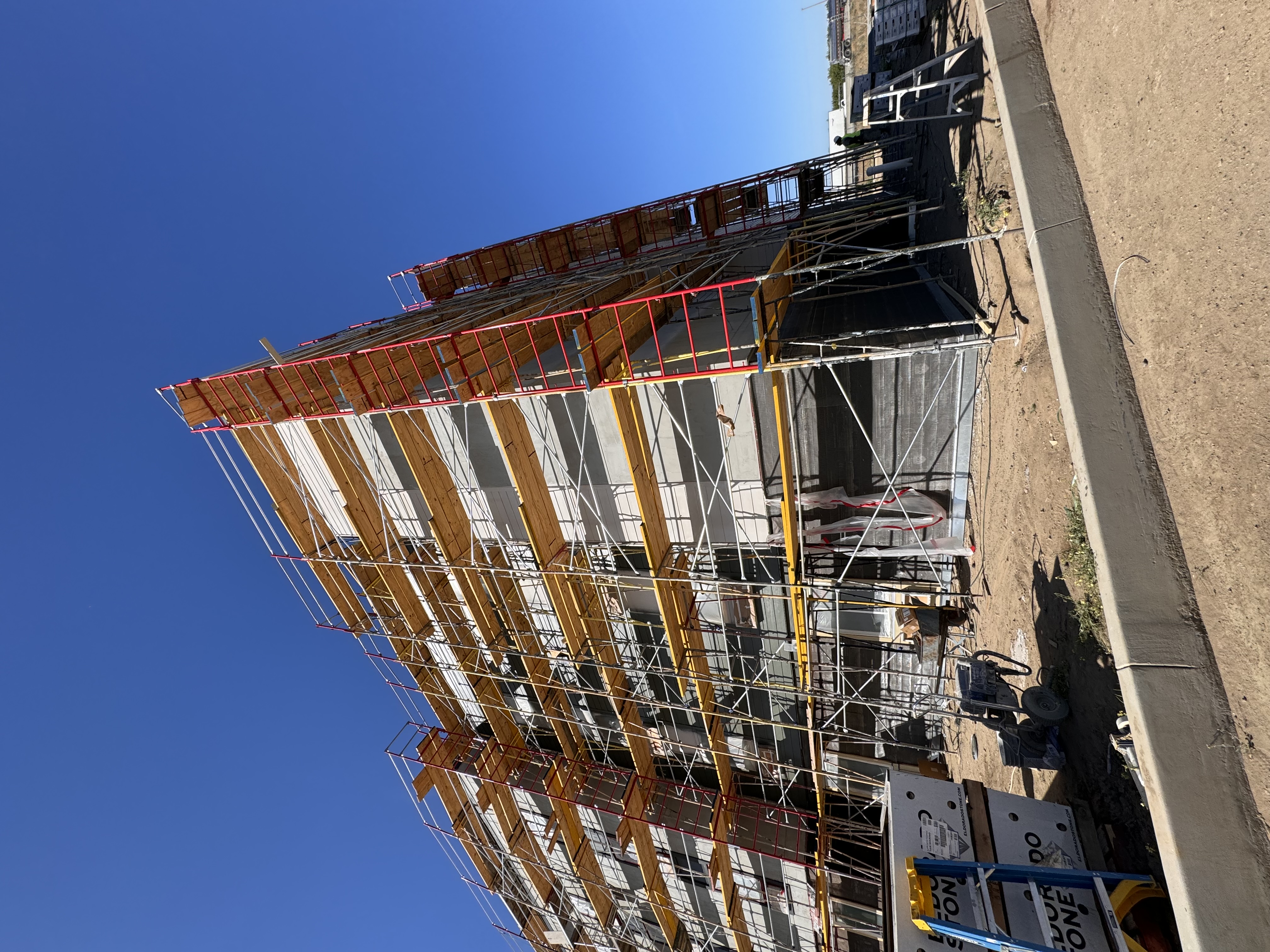 Hotel siding scaffold Eldorado stone pallets on ground